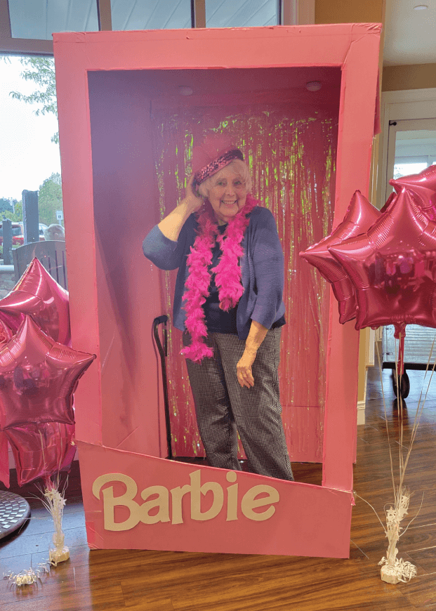 senior woman posing in a Barbie style box photobooth