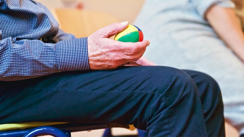 Man holding occupational therapy ball